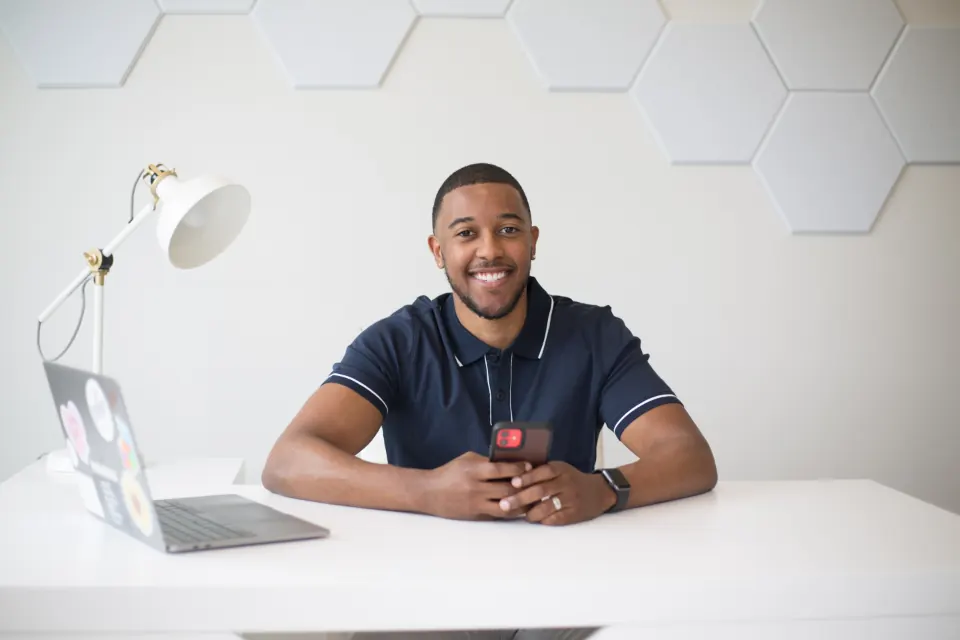 A coach smiling at his desk